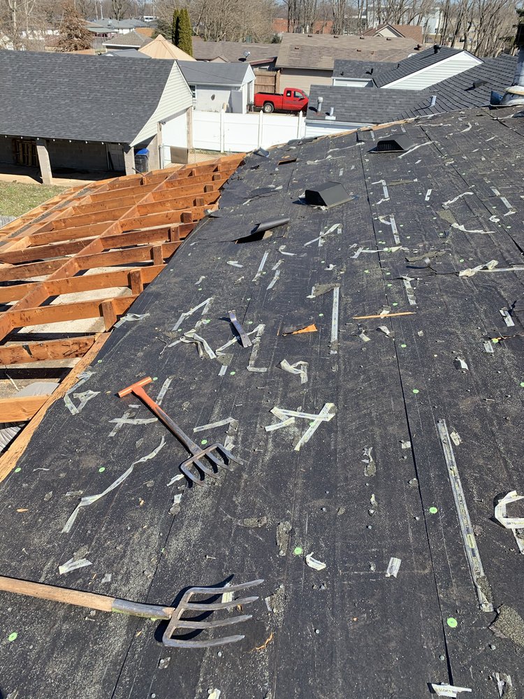 Roof replacement in progress with underlayment and exposed rafters